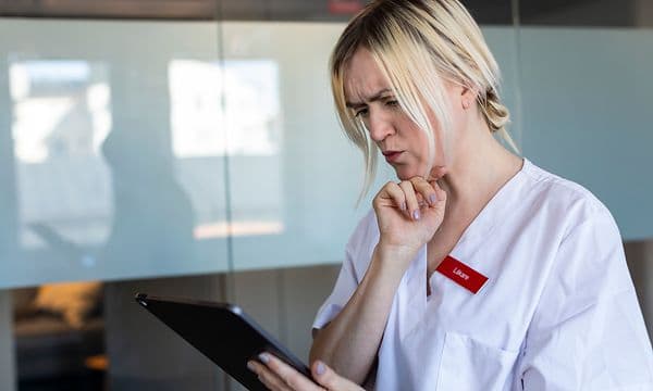 Hoitaja katsoo tuimana iPadin näyttöä