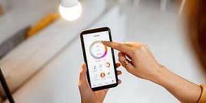 Kvinna som kontrollerar lampor med hennes telefon