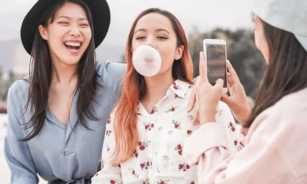 Kvinde bruger sin smartphone til at filme to kvinder