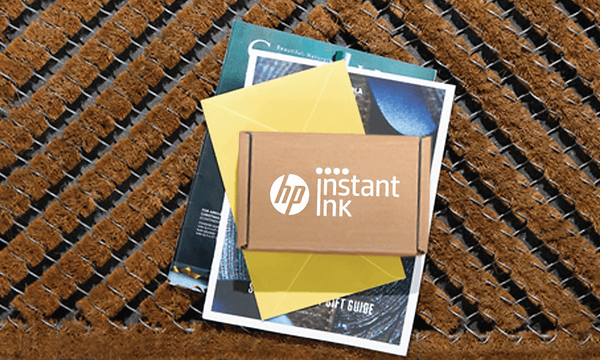 Kvinde holder op udskrift ved siden af en HP-printer