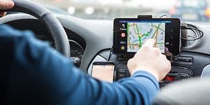 Mand der sidder i en bil og trykker på GPS-skærmen