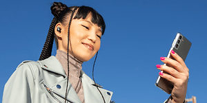 Headphones-Beats-Kvinne med Studio Buds Sound ser på mobi