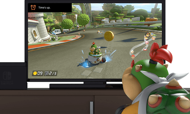 Nintendo switch med bild på ett monster som sitter framför en skärm som visar ett TV-spel.