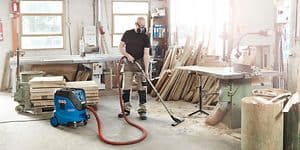 Man vacuuming workshop floor with Nilfisk Attix 44-2M IC