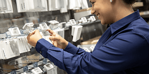 Corporate - Sustainabillity - Salesperson merchandising cables in store