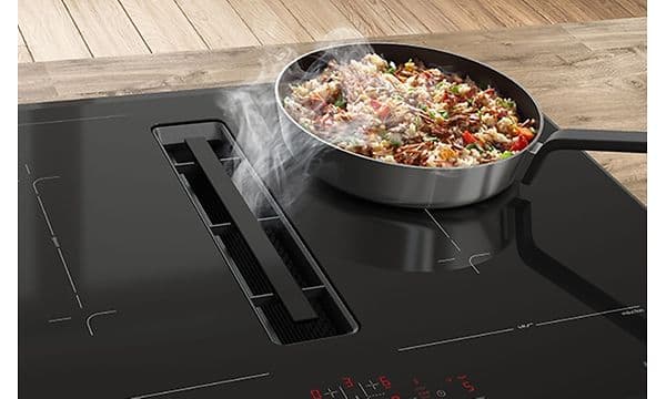 Bosch kogeplade med integreret emhætte, hvorpå der laves wok
