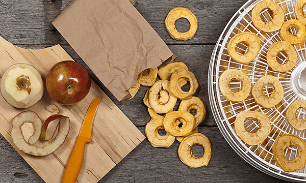To hele æbler og tørrede æbleskiver i en dehydrator