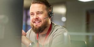 Kundeservicemedarbeider som smiler og snakker i headset