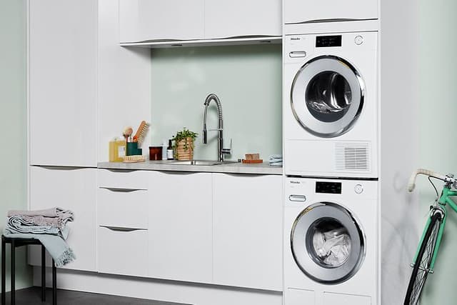 Washer and dryer in a laundry room with white and green interior