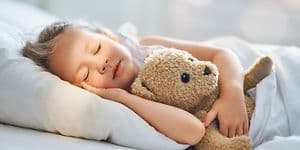 Pige sover med sin bamse