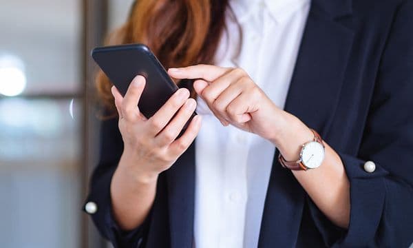 Businesswoman holding and using mobile phone