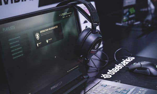 Bærbar datamaskin med gaming-headset som henger på skjermen
