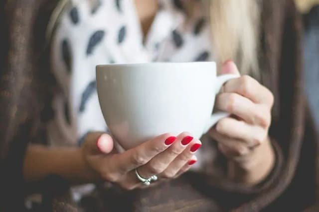 Nærbilde av kvinne som holder stor kaffekopp