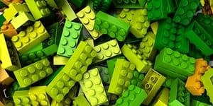 Lego-klossar i olika grön/gula nyanser i en hög. 