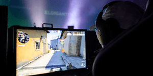 Person med headset sidder foran computeren og gamer