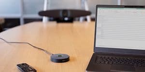 IRIS video konferencesystem på et mødebord ved siden af en laptop