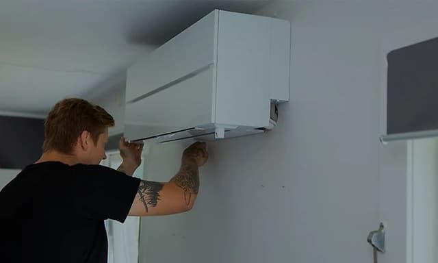 Mann som installerer en varmepumpe