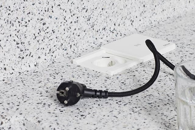 White EVOLine Square80 socket with a wire next to it on a kitchen worktop
