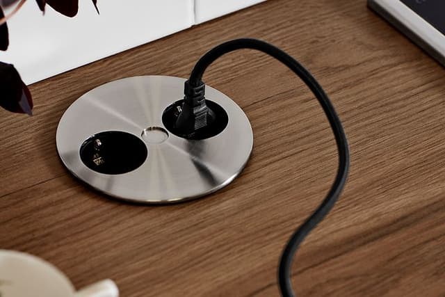 Epoq Twist -uttag med kontakt ikopplad på en träbänkskiva.