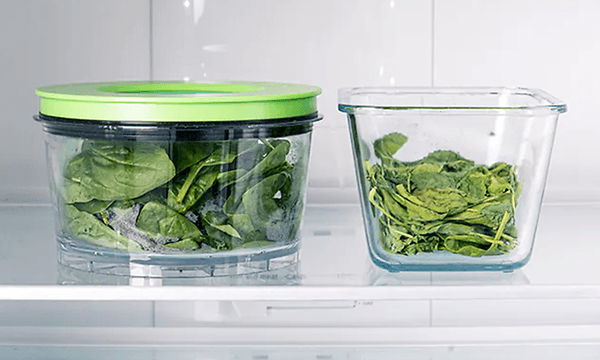 Två matlådor i glas med vacuumförpackad sallad inuti. 