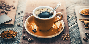 En kop espresso med kaffebønner omkring