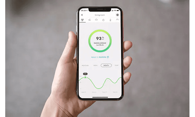 En smarttelefon i en hånd som viser radonnivåer i Airthings -appen