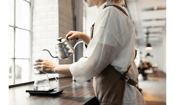 En person heller kaffe over fra en kanne