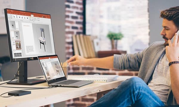 Mand snakker i telefon og arbejder på sin Lenovo laptop