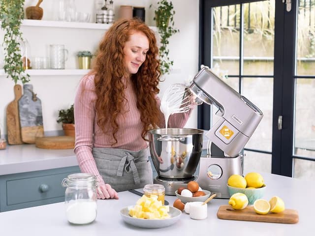 SDA-Kitchen machines-Woman with Kenwood kitchen machine in steel in a kitchen