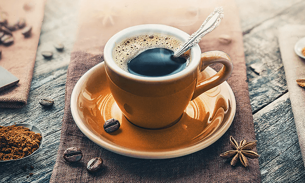 Espressokuppi, ympärillä kahvipapuja