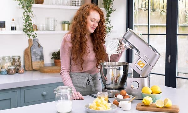 SDA-Kitchen machines-Woman with Kenwood kitchen machine in steel in a kitchen