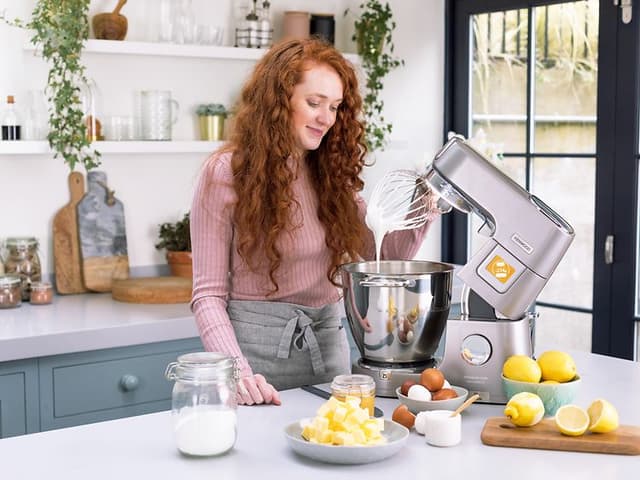 SDA-Kitchen machines-Woman with Kenwood kitchen machine in steel in a kitchen