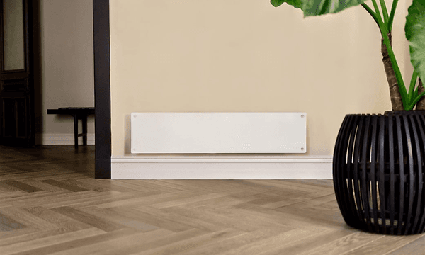 Vitt långsmalt element från Mill placerat på en beige vägg med en stor växt bredvid. 