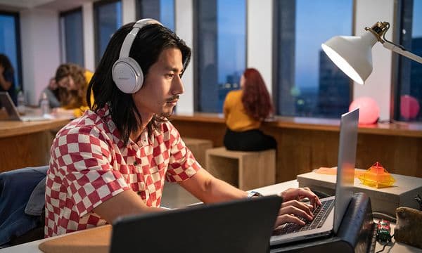Mann med Bose QC45 hodetelefoner jobber på kontor