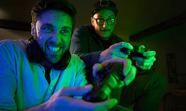 Philips Hue hemmabio, två män som spelar med konsoler i högsta hugg. 
