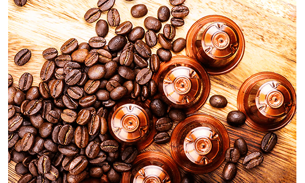 Kaffekapsler og kaffebønner på et bord
