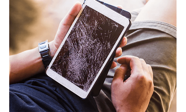Mies pitelee kädessään tablettia, jonka näyttö on rikki
