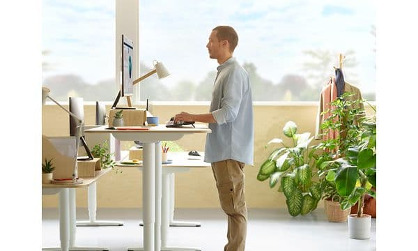 Mies pöydän ääressä käyttää ergonomista näppäimistöä