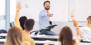 Airthings Wave Plus på vegg i klasserom bak lærer og elever