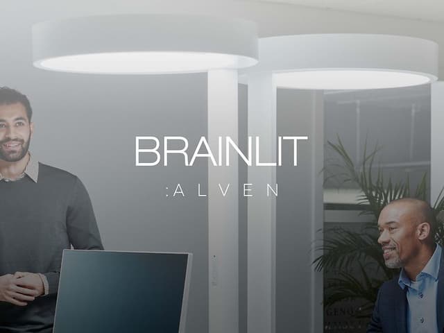 bilde av et kontormiljø I gråtoner med brainlit-lys og bedriftslogo på topp av bildet