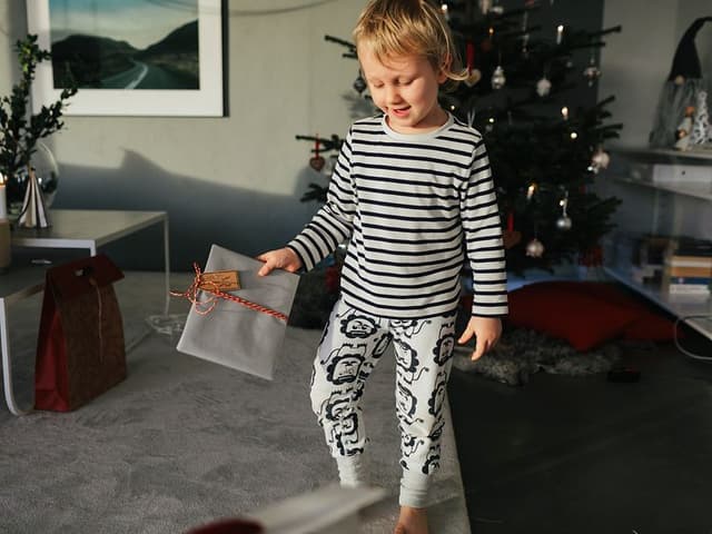 Ett glatt barn håller i en julklapp