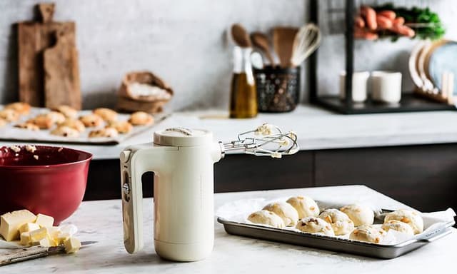 KitchenAid kremfarget håndmikser med scones ved siden av