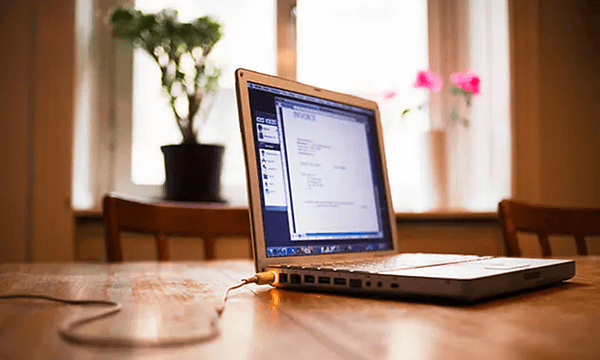 en laptop på et mord med ladekabel koblet i