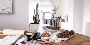 Køkkenmaskine på et køkkenbord sammen med æg og muffins