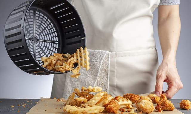 Person som heller pommes frites utover bakepapir