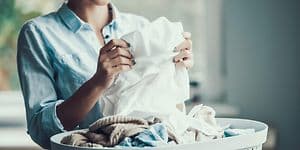 Woman folding laundry from a laundry basket