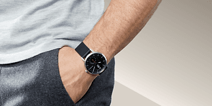 Withings - Mies Withings-älykello ranteessaan ja käsi housun taskussa