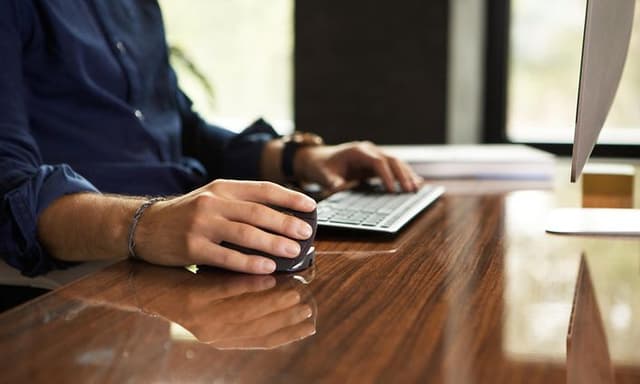 Mand bruger Contour Unimouse, imens han arbejder foran en computer