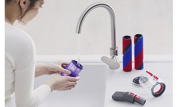 En kvinde vasker Dyson Omni-Glides vaskbare dele, som gør støvsugeren nem at vedligeholde