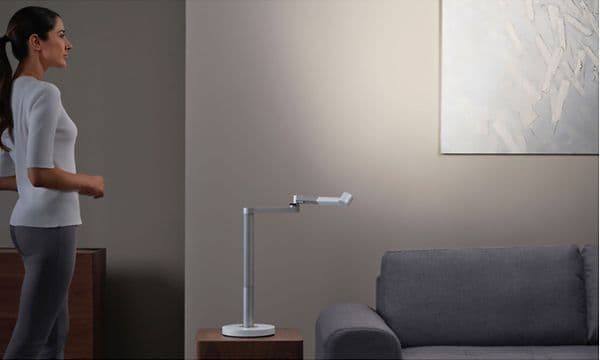 Kvinde stående ved siden af en Dyson-lampe